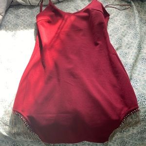 Wine red tight dress . Charms dangling from the sides to give it a sexy look .